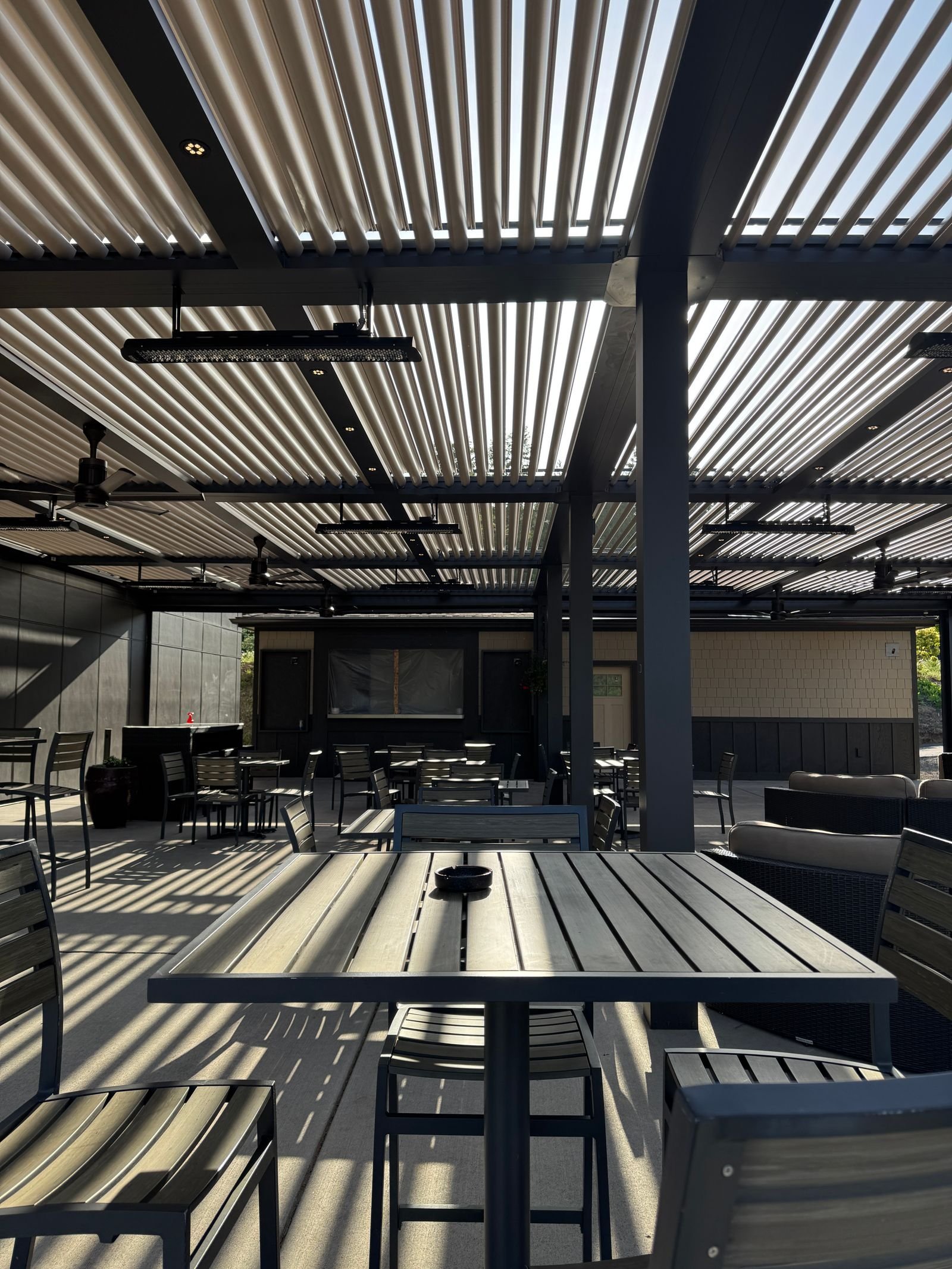 Gerçek alüminyum lamelli pergola altında restoran oturma alanı